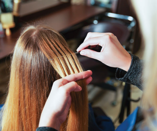 Hairdresser applying highlights to lady with long hair