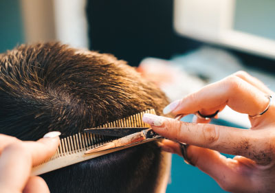 hairdresser cutting man's hair with short haircut