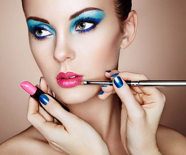 woman with bright blue eyeshadow and bright pink lipstick