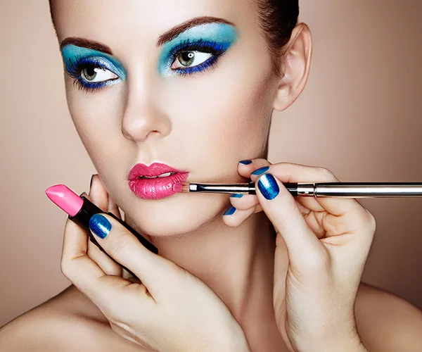 makeup consultation woman with bright blue eyeshadow and bright pink lipstick