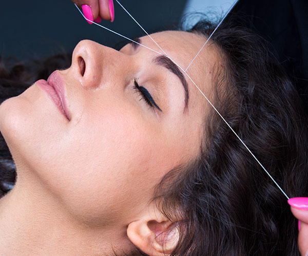 lady with eyes closed having a threading treatment