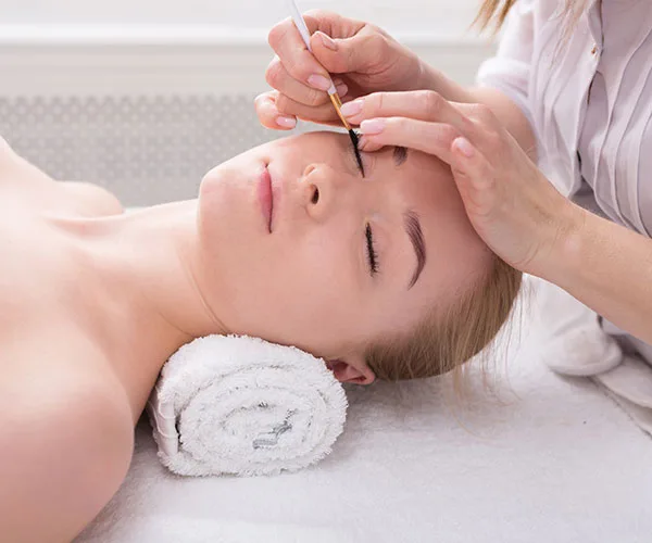 eyelash tinting lady lying on bed getting her eyelashes tinted