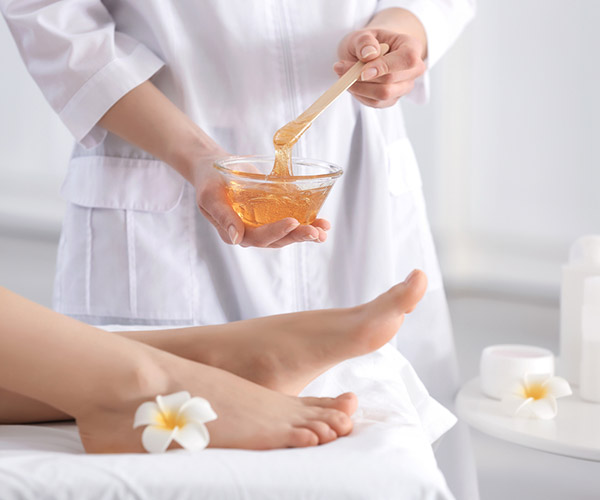 lady holding bowl of hot wax for hair removal