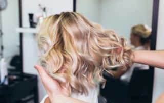 Girl in hairdressing salon with blond balayage hair