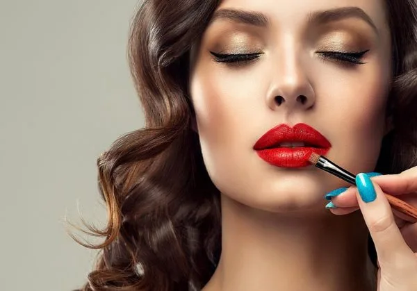 makeup consultation woman with eyes closed having lipstick put on