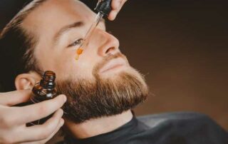 applying beard oil on a man's beard